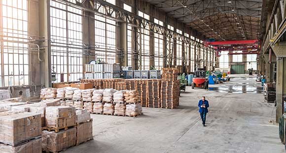 Man in suit walking through warehouse